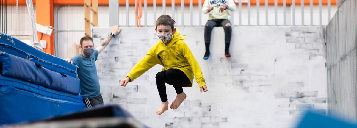 image of a youth student jumping on trampoline